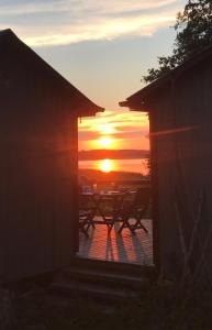 a sunset seen through the window of a house at Cottage with sauna and kayaks in Hammarland +11 photos