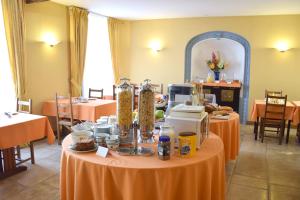 une chambre avec deux tables avec des nappes orange dans l'établissement Logis Le Saint Nicolas, à Bar-sur-Aube