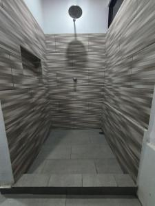 a bathroom with a shower with a shadow of a person at Casa Abierta Playa Juquillal 1 habitacion in Santa Cruz