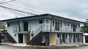 a white house with stairs on the side of it at Hotel Nativo Arenal in Fortuna