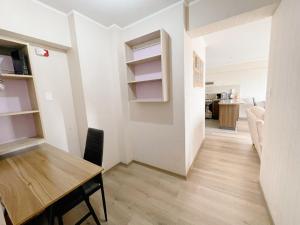a dining room with a table and a kitchen at Habitación privada con baño privado y smart TV in Lima