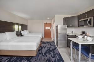 a hotel room with a large bed and a kitchen at Quality Inn & Suites in Winnipeg +74 photos