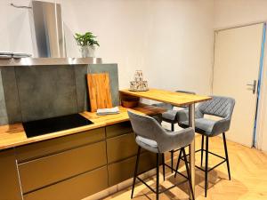 a kitchen with a counter with a table and chairs at Apartmán u Vetešnictví in Vítkovice