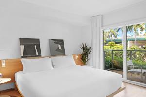 a bedroom with a white bed and a large window at Beach Haus Bal Harbour in Miami Beach +42 photos