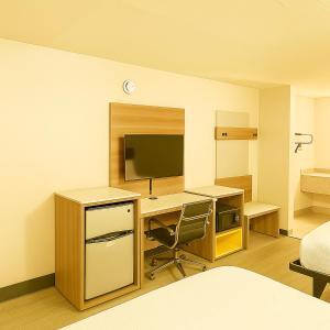 a room with a desk with a computer and a bed at Economy Inn Little Rock in Little Rock