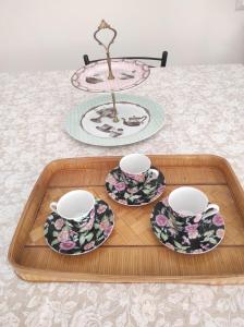 a tray with three cups and saucers on a table at Elena 's HOME in Conversano