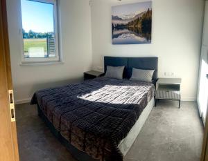 a bedroom with a bed and a large window at Domek pod lasem in Bolmin