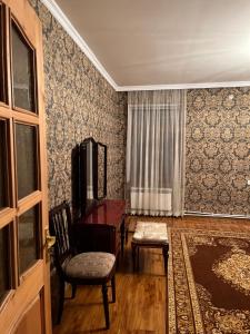 a living room with a piano and a chair at Дом in Bavra