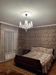 a bedroom with a bed and a chandelier at Дом in Bavra