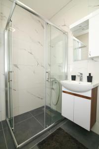 a bathroom with a glass shower and a sink at Ege Guest House in Ohrid