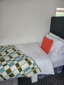 a bed with two pillows on it in a room at Posyrooms Apartment in Stalybridge +2 photos