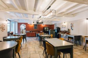 圣马洛Logis Hôtel la Grassinais Saint-Malo的一间有桌椅和厨房的餐厅