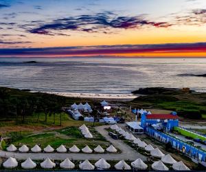 z góry widok na plażę z namiotami i ocean w obiekcie Glamping Atlántico w mieście Ferrol