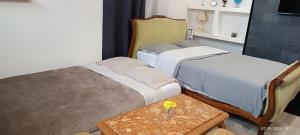 a room with two beds and a table with a vase on it at Gite Artur in Bar-sur-Aube