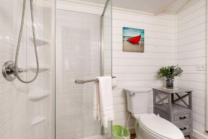 a white bathroom with a toilet and a shower at Reece Cottage in Ellsworth +12 photos