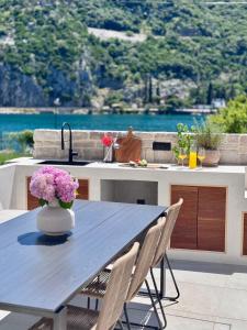 a kitchen table with a vase of flowers on it at Pool 4 Leisure Dubrovnik in Dubrovnik +17 photos