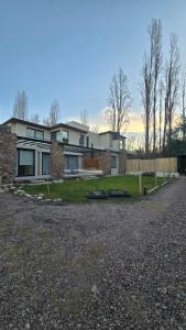 a brick house with a fence and a yard at Casa Reserva Vip in Ciudad Lujan de Cuyo