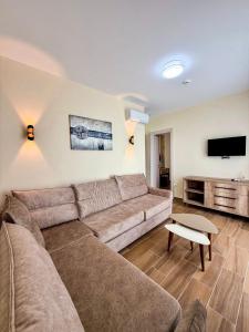a living room with a couch and a flat screen tv at Villa Blanc in Shëngjin +38 photos