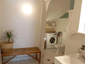 a bathroom with a toilet and a washing machine at Sunset Dafnes beach in Patra
