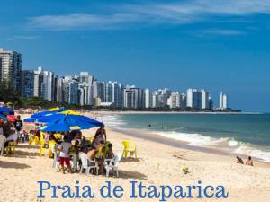 a beach with people sitting under umbrellas and the ocean at Mar de Itaparica 2 quartos, apenas 450 metros da praia in Vila Velha