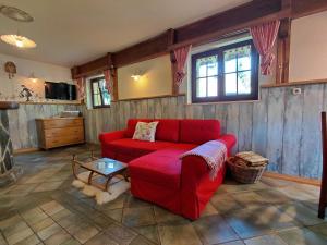 a living room with a red couch and a table at Apartma Alpski vrt in Vojsko