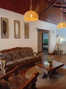 a living room with a couch and a table at Recanto Sol Maior - Casa Girassol in Sapucaí-Mirim