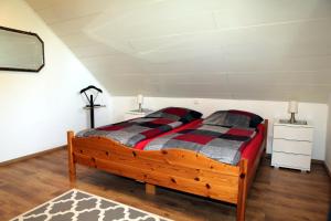 een slaapkamer met een houten bed in een kamer bij Ferienhaus Domus in Xanten