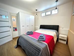 a bedroom with a bed with a red blanket at One-Bedroom House close to the Beach in Armação de Pêra