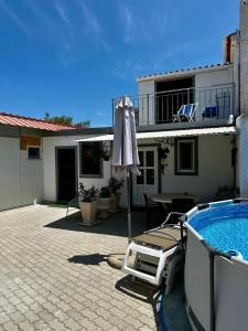 a patio with an umbrella and a swimming pool at One-Bedroom House close to the Beach in Armação de Pêra