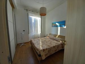 een slaapkamer met een bed en een groot raam bij Sweet Adry in Genua