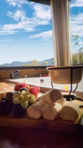 a cutting board with fruit on a table with a window at Morada da Pedra in Praia Grande
