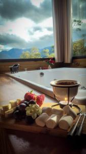a cutting board with fruit and a candle on a table at Morada da Pedra in Praia Grande