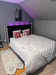 a bedroom with a large white bed with purple ceilings at Ô Saphir Spa - Maison N3 in Denain