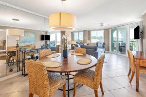 Un comedor y una sala de estar con mesa y sillas. en North Breakers #503, en Saint Simons Island