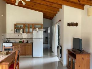 a kitchen with a white refrigerator and wooden cabinets at Pax Costa del Este in Costa del Este