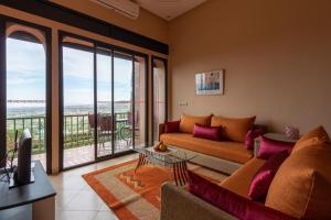a living room with a couch and a large window at Marrakech Le Joyau de l'ourika in Ourika