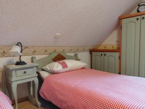 a bedroom with a bed and a table with a lamp at Apartma Alpski vrt in Vojsko