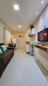 a living room with a couch and a flat screen tv at Flats Stúdio Serra Talhada in Serra Talhada +13 photos