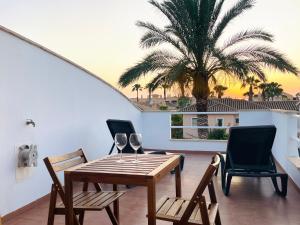 a dining room with a table and chairs and a palm tree at TrendyHomes Laguna Beach in Vera