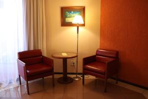 a room with two chairs and a table and a lamp at Hotel Princesa Louçã in Belém