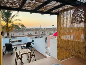 a balcony with chairs and tables and a view of the city at TrendyHomes Laguna Beach in Vera