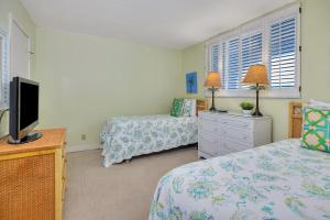 a bedroom with two beds and a flat screen tv at North Breakers #502 in Saint Simons Island +23 photos