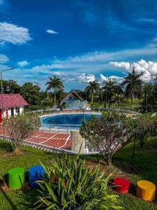 a swimming pool in a yard with palm trees at Casa Amoblada en Conjunto Villavicencio in Villavicencio