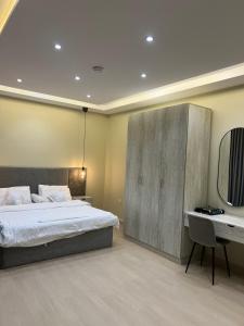 une chambre avec un grand lit et un bureau dans l'établissement شقة جديدة وفاخرة بالقرب من الحرم ., à Sīdī Ḩamzah 76 autres photos