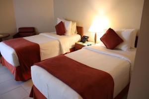 a hotel room with two beds and a phone on a table at Hotel Princesa Louçã in Belém +22 photos