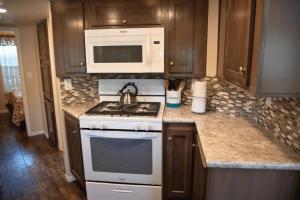 una cocina con estufa y microondas en Sunset Mesa Cabin #21, en Moab