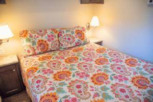 1 dormitorio con 1 cama con colcha de flores y 2 lámparas en Sunset Mesa Cabin #21, en Moab