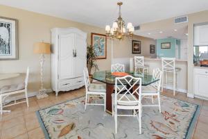 Un comedor y una cocina con una mesa de cristal y sillas. en North Breakers #412, en Saint Simons Island