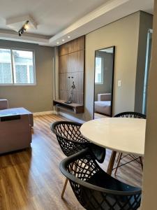 una sala de estar con una mesa y sillas en 1-Apto 1 dorm Barra Sul com VAGA, en Balneário Camboriú