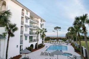 una vista exterior de un hotel con piscina y palmeras en North Breakers #408, en Saint Simons Island